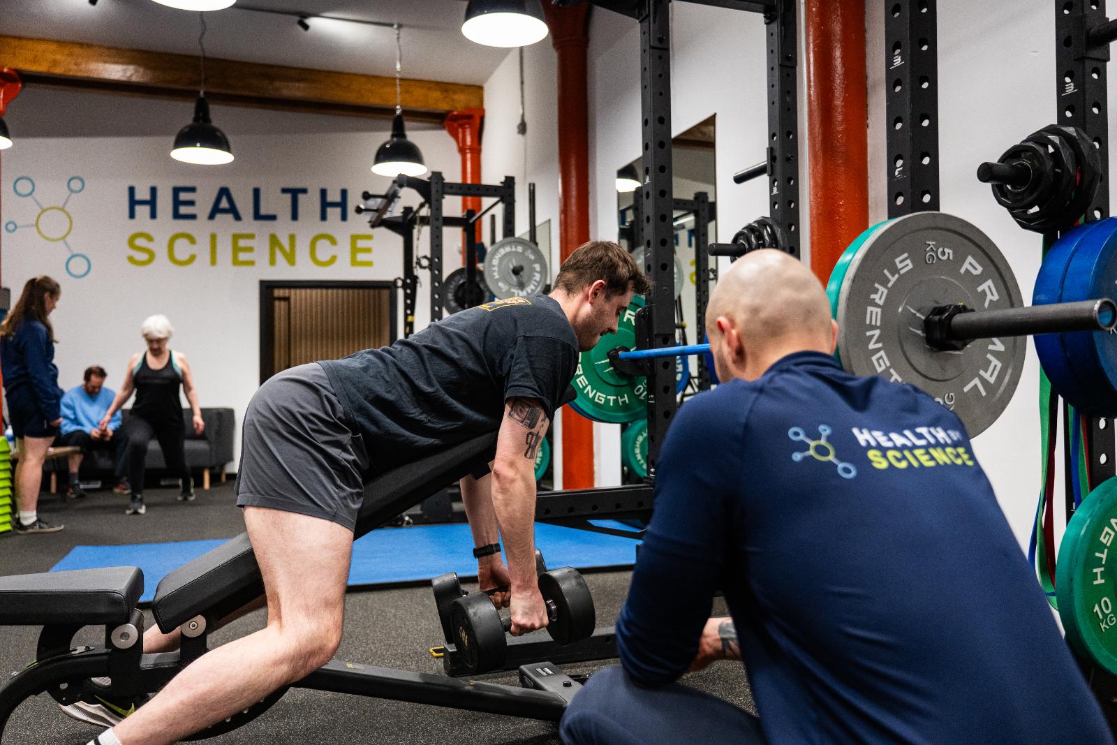 KA3_3605 Health by Science coach monitoring lifting mechanics during a strength-based rehabilitation session at our Leith clinic.